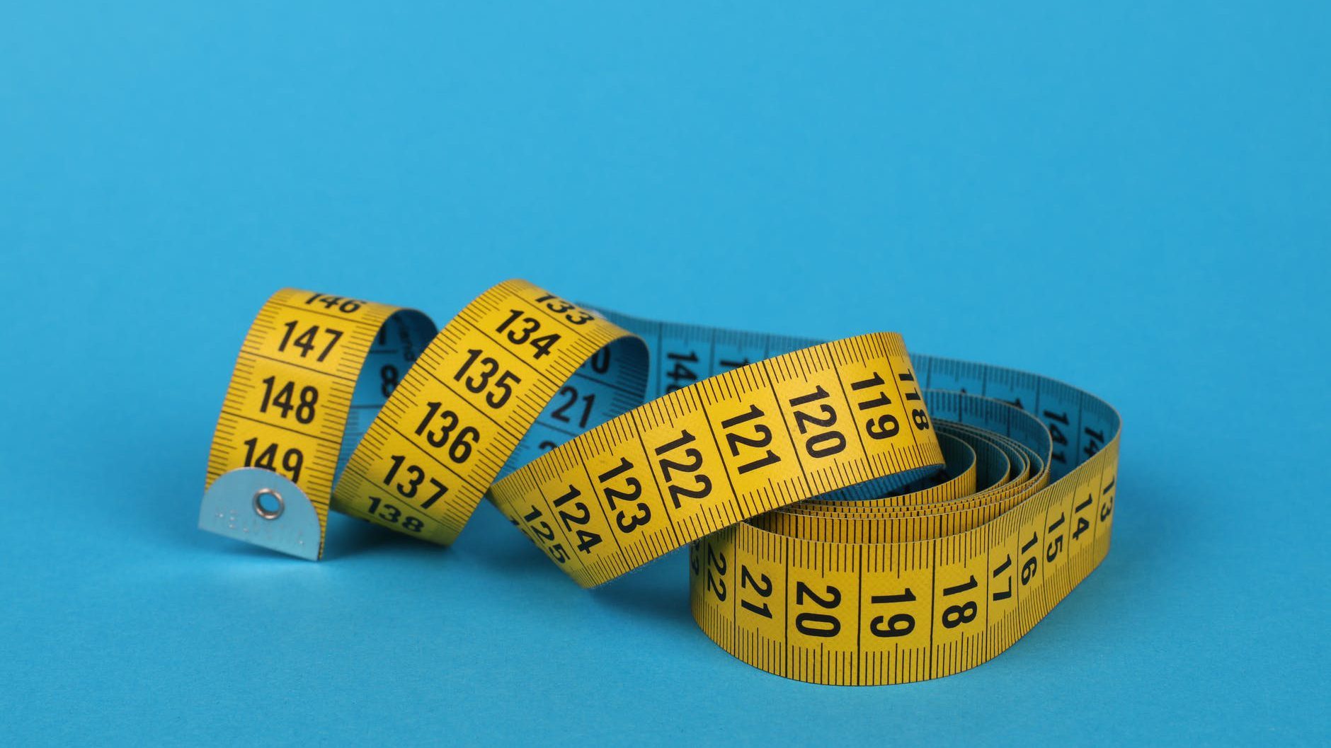 yellow tape measure on blue background