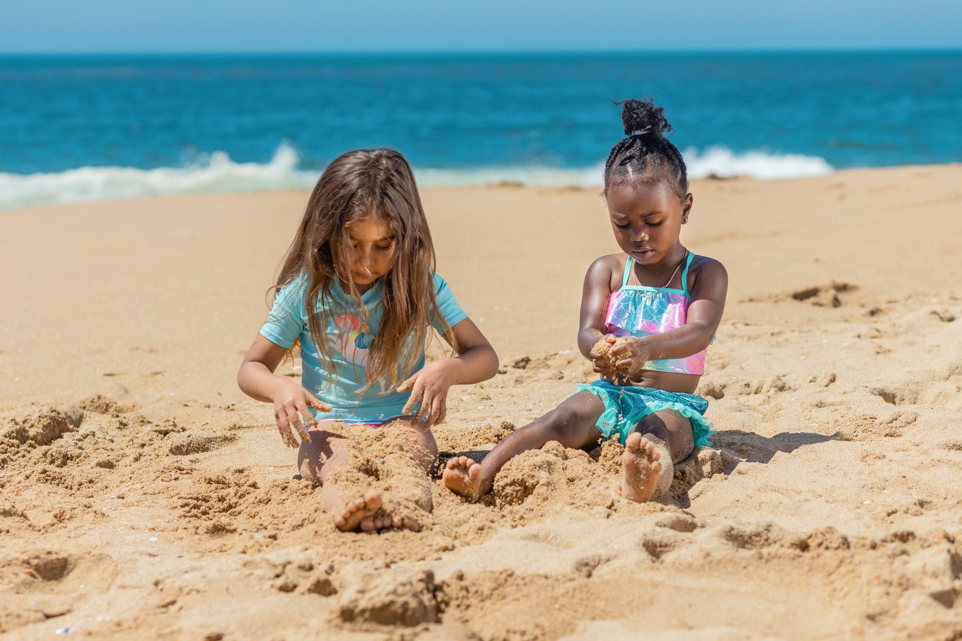 a young girls playing sand on the beach