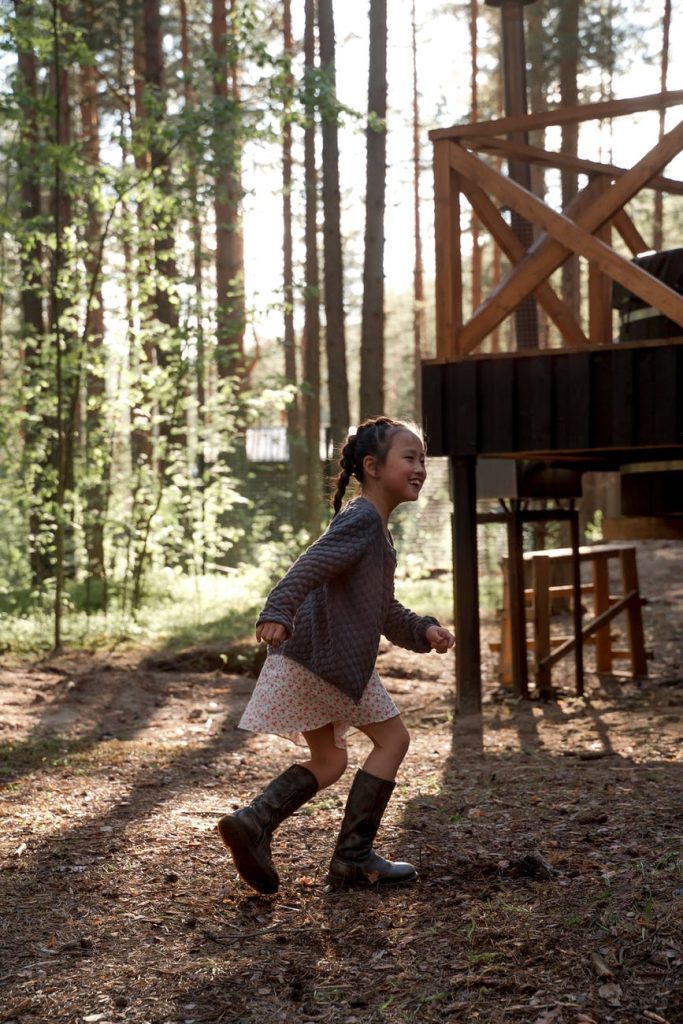 a young girl in boots running while playing